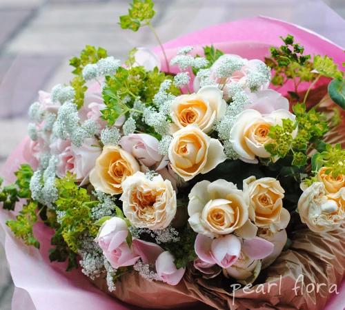 白や淡い色のバラをピンクのラッピングで包んだ、パールフローラの花束