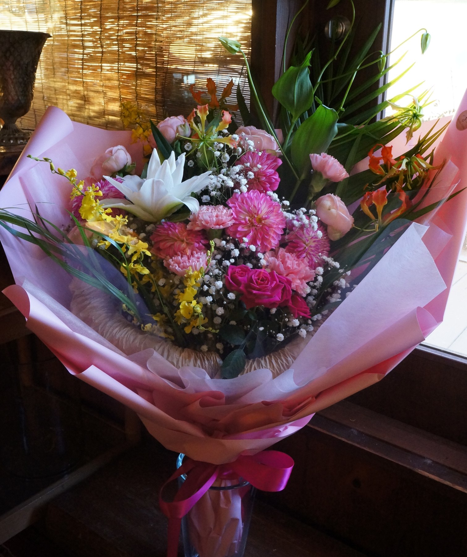 女性への贈り物にお作りしたピンク・白・黄色の華やかな花束